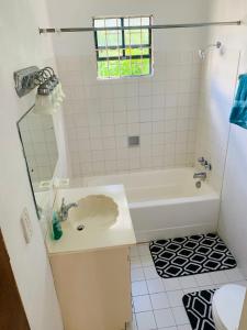 a bathroom with a white tub and a sink at Ocean View Apartments By-BLR in Bridgetown