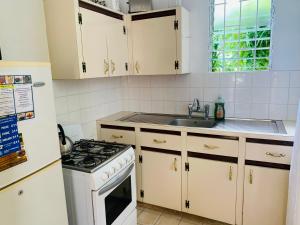 a kitchen with white cabinets and a stove top oven at Ocean View Apartments By-BLR in Bridgetown