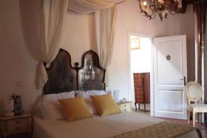 ein Schlafzimmer mit einem Bett mit zwei gelben Kissen in der Unterkunft Il Lupo Rosso in Santu Lussurgiu