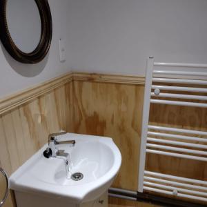 y baño con lavabo blanco y espejo. en Departamentos Kitkaika en Punta Arenas