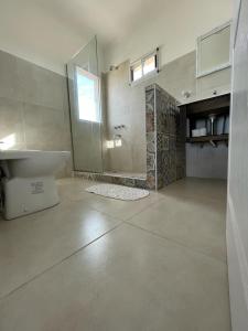 a bathroom with a tub and a sink and a shower at Las Piedritas Monoambiente Vista in Las Grutas +30 photos