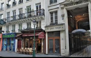 una strada con negozi e un lampione di fronte a un edificio di Bel appartement au cœur de paris a Parigi
