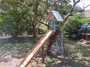 une aire de jeux avec toboggan et arbre dans l'établissement Sítio das Jaqueiras, à Bom Jardim