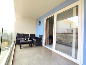een balkon met een tafel en stoelen en een groot raam bij Sliema Central 3 Bedroom Apartment Near Seafront in Sliema