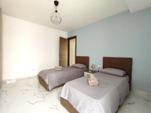 twee bedden in een kamer met witte muren bij Sliema Central 3 Bedroom Apartment Near Seafront in Sliema