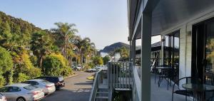 einen Balkon eines Gebäudes mit Autos, die auf einer Straße geparkt sind in der Unterkunft Bounty Motel in Paihia