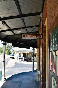 een gebouw met een bord waarop de ontvangst staat bij Ten Dollar Town Motel in Gulgong