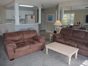a living room with two brown couches and a table at Brunswick Plantation Golf Resort 1509M in Calabash