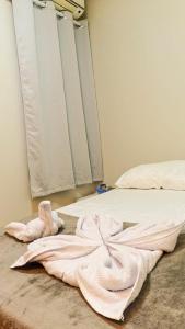 una camera da letto con un letto bianco e un asciugamano sul pavimento di Honório pousada - Tucano BA a Tucano