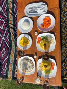 a wooden table with plates of food on it at Batur Cozy Bali in Kintamani