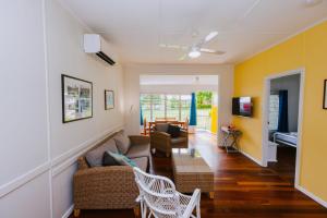 a living room with yellow walls and a couch at Kooyong Apartment 4 in Arcadia