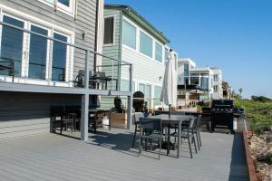 a deck with a table and chairs on a house at Luxury Beachfront Condo - Endless Views - Surf 1 in Sunset Beach