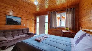 a bedroom with a bed and a couch in a room at Pousada da Gruta in Urubici