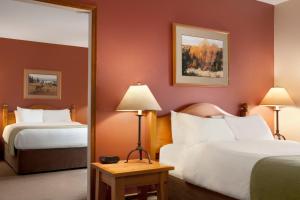 a hotel room with two beds and a mirror at Sundance Lodge in Sun Peaks