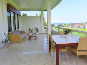 a patio with a table and chairs and a couch at Medewi Manor in Airsatang