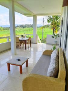 a living room with a couch and a table at Medewi Manor in Airsatang