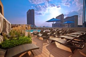 a row of lounge chairs and a pool on a rooftop at The Colonnade Hotel in Boston