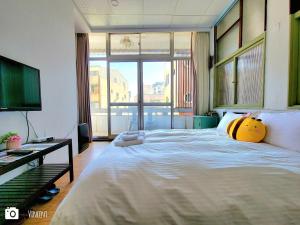 una camera da letto con un grande letto con un cuscino giallo di Honey House Tainan a Tainan