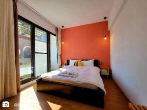 una camera da letto con una parete arancione e un letto di Honey House Tainan a Tainan