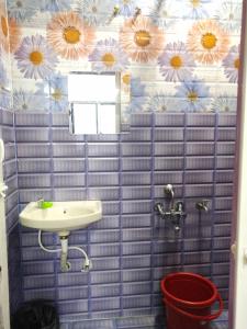 a blue tiled bathroom with a sink and a bucket at Villa Blossom, Near Serenity Beach in Puducherry