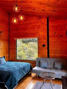 sypialnia z łóżkiem, kanapą i oknem w obiekcie Villa Skape - Finca Villa Carolina w mieście Villa de Leyva