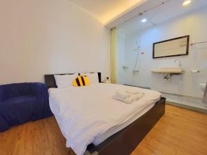una camera da letto con un letto con un cuscino giallo sopra di Honey House Tainan a Tainan Altre 36 foto