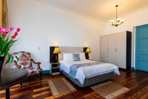 1 dormitorio con 1 cama y 1 silla en Del Parque Hotel & Suites, en Cuenca