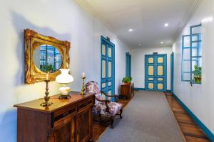 un corridoio con pareti bianche e blu e uno specchio di Del Parque Hotel & Suites a Cuenca