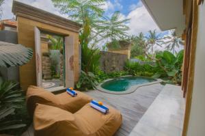 a patio with a jacuzzi tub in a garden at Govala Ubud Villas & SPA in Ubud