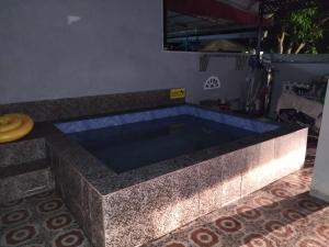 a swimming pool in a house with a stone tub at Yatida Homestay - Guest House Port Dickson in Port Dickson
