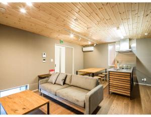 uma sala de estar com um sofá e uma cozinha em Rakuten STAY HOUSE x WILL STYLE Matsue 103 em Matsue