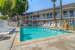 a swimming pool in front of a hotel with lounge chairs at Motel 6-El Cajon, CA - San Diego in El Cajon