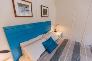 a bed with a blue headboard in a bedroom at Kooyong Apartment 5 in Arcadia