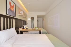 Habitación de hotel con 2 camas y mesa en 银座精宿济南长清大学城店 en Changqing