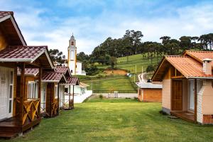 a row of houses with a clock tower in the background at Pousada da Gruta in Urubici