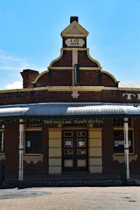 a red brick building with a clock tower on top at Ten Dollar Town Motel in Gulgong