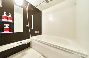 a white bathroom with a tub and a mirror at Rakuten STAY HOUSE Kisarazu in Kisarazu