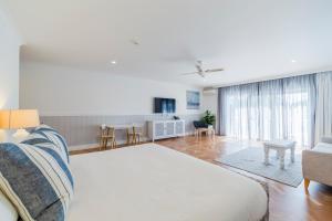 a bedroom with a large bed and a living room at The Quarters, Ascend Hotel Collection in Wamberal