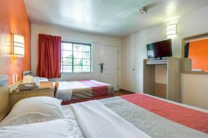 a hotel room with two beds and a television at Motel 6-Pomona, CA - Los Angeles in Pomona