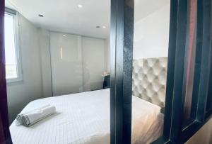 a bedroom with a white bed and a mirror at Le Château Leenhardt in Le Grau-du-Roi