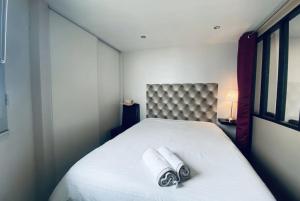 a bedroom with a bed with two towels on it at Le Château Leenhardt in Le Grau-du-Roi