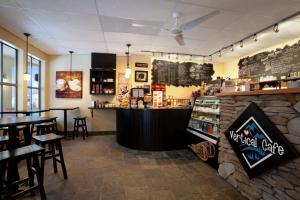 a bar in a restaurant with a counter and tables at Sundance Lodge in Sun Peaks