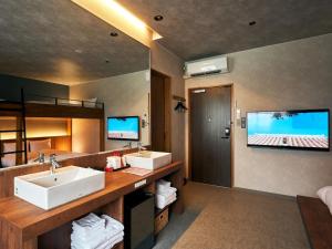 baño con 2 lavabos y TV de pantalla plana en Rakuten STAY Naha-Miebashi Bunk bed Room, en Naha