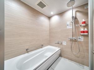 a bathroom with a white tub and a shower at Rakuten STAY Naha-Miebashi Accessible Twin Room in Naha