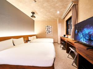 a hotel room with two beds and a flat screen tv at Rakuten STAY Naha-Miebashi Accessible Twin Room in Naha