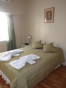 Un dormitorio con una cama con toallas. en Hotel Aoma Buenos Aires, en Buenos Aires 15 fotos más
