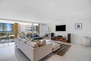 a living room with a couch and a tv at Maili 6 Luxury sky home in Gold Coast