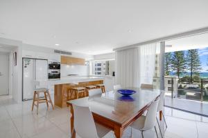 cocina y comedor con mesa y sillas en Maili 6 Luxury sky home, en Gold Coast