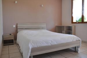 a bedroom with a bed with white sheets and a window at Hôtel Restaurant La Casera in Clarac