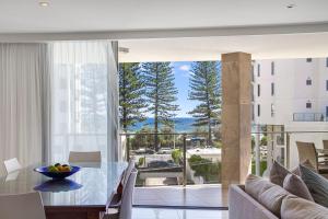 comedor con mesa y vistas al océano en Maili 6 Luxury sky home, en Gold Coast